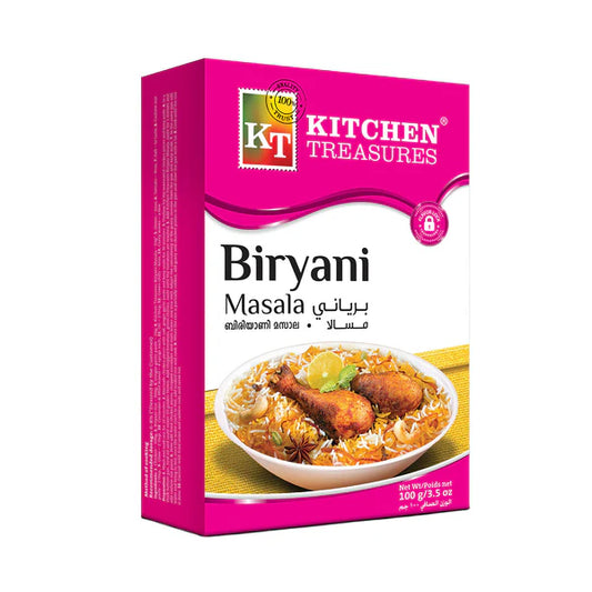 A professional studio shot of a 100 g box of Kitchen Treasures Biryani Masala. The cardboard box features a two-tone design with a vibrant magenta top and side panel, and a clean white face. The "KT Kitchen Treasures" stamp-style logo sits inside the magenta wave section above a pink "Flavor Lock" padlock graphic. The center of the box reads "Biryani Masala" in bold black lettering with translations in Arabic, Malayalam, and Hindi. This product is available in the UK at theindianshelf.co.uk.