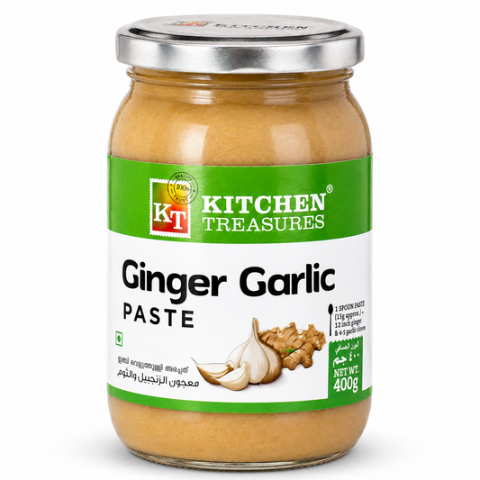A professional studio shot of a 400g glass jar of Kitchen Treasures Ginger Garlic Paste The label has a prominent green top section with the "KT Kitchen Treasures" logo. The middle of the label shows a high-quality graphic of fresh garlic cloves and ginger root. Key highlights such as "100% Natural Ingredients" and "No Added Preservatives & Colours" are clearly visible.This product is available in the UK at theindianshelf.co.uk.