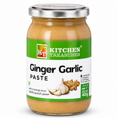 A professional studio shot of a 400g glass jar of Kitchen Treasures Ginger Garlic Paste The label has a prominent green top section with the "KT Kitchen Treasures" logo. The middle of the label shows a high-quality graphic of fresh garlic cloves and ginger root. Key highlights such as "100% Natural Ingredients" and "No Added Preservatives & Colours" are clearly visible.This product is available in the UK at theindianshelf.co.uk.