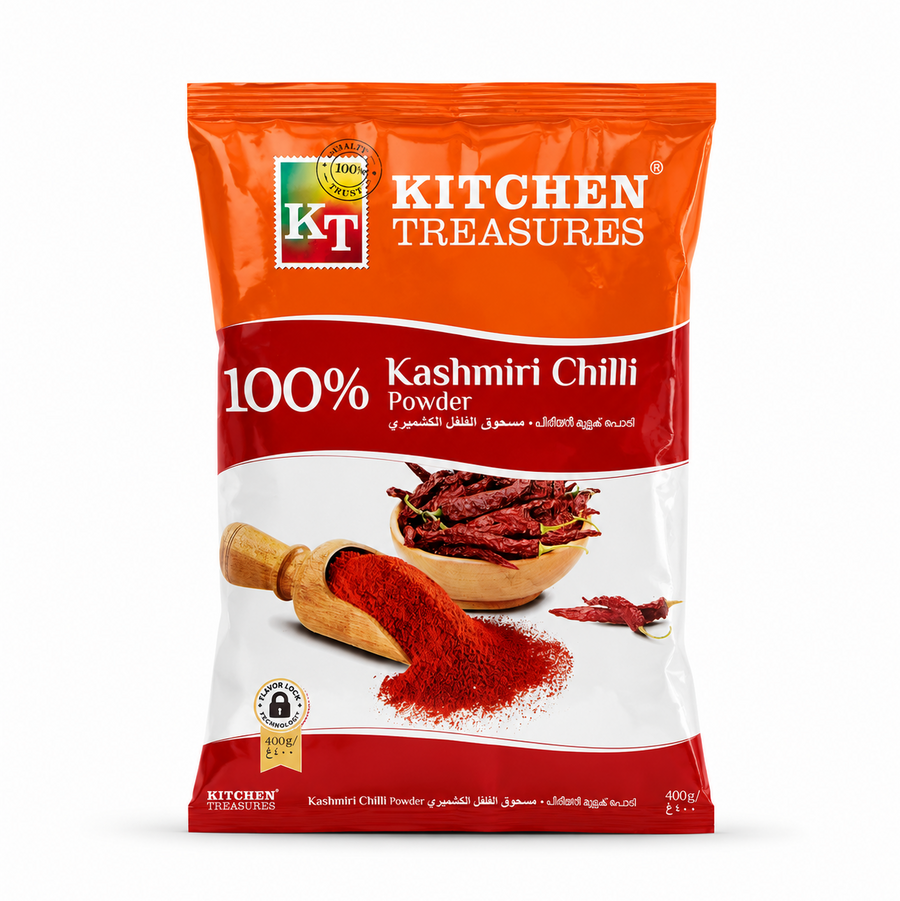 A professional studio product shot of a 400g pouch of Kitchen Treasures 100% Kashmiri Chilli Powder isolated against a pure white background in image_85357b.jpg. The orange, red, and white packaging features a wooden scoop spilling vibrant red chili powder alongside a small wooden bowl piled high with whole dried wrinkled red chillies.