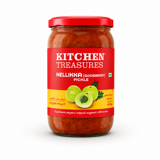 A professional studio shot of a 400g glass jar of Kitchen Treasures Nellikka (Gooseberry) Pickle. The jar reveals a rich, red-orange spiced pickle base inside and is topped with a glossy red metal lid. The centered bright red label reads "KITCHEN TREASURES" in bold white lettering, followed by "NELLIKKA (GOOSEBERRY) PICKLE". The lower section of the label transitions into a bright yellow band featuring a crisp graphic of three green gooseberries.This product is available in the UK at theindianshelf.co.uk.