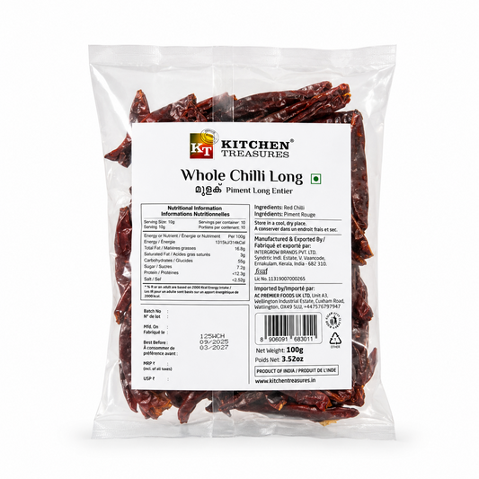A professional studio product shot of a 100g clear pillow pouch of Kitchen Treasures Whole Chilli Long isolated against a pure white background in image_971bc0.jpg. The transparent packaging clearly showcases the textured, deep crinkled crimson whole red chillies packed inside, centered behind a clean white information label displaying nutritional tables, barcodes, and manufacturing details. This product is available in the UK at theindianshelf.co.uk.