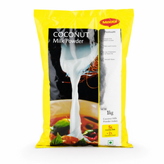 A professional studio shot of a 1kg bag of Maggi Coconut Milk Powder. The packaging is bright yellow with a large black and white central graphic showing thick white coconut milk being poured from a shell. The red "Maggi" logo is at the top right. Key features are listed with checkmarks: "Made from Real Coconut," "Rich and Creamy," "Low Cholesterol or Trans Fat," and "Smooth Texture." A yellow box at the bottom highlights that the 1kg pack makes 5L of Coconut Milk or 2L of CoconutThis product is available i