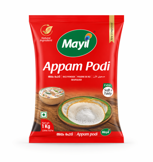 A professional studio shot of a 1kg packet of Mayil Appam Podi. The packaging is "Mayil" peacock logo at the top. The center showcases a beautiful serving suggestion: two golden-edged, white Appams on a green banana leaf, accompanied by a small bowl of creamy white vegetable stew. A green "Natural Ingredient" leaf icon and an "Extra Soft & Tasty" seal are clearly visible on the front. The net weight is marked as 1 kg / 2.20 lbs.This product is available in the UK at theindianshelf.co.uk.