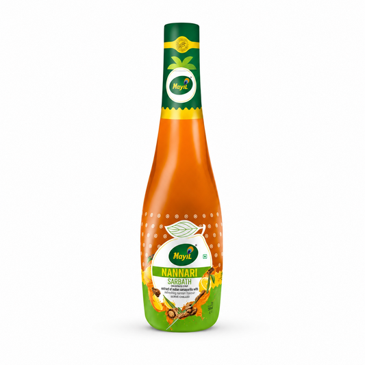 A professional studio product shot of a contoured bottle of Mayil Nannari Sarbath concentrated syrup against a solid white background. The bottle has a long dark green neck featuring a small circular peacock feather "Mayil" logo, transitioning down into a bright amber-orange body filled with liquid concentrate. The main central label displays the brand name "Mayil" inside a white circle,This product is available in the UK at theindianshelf.co.uk.