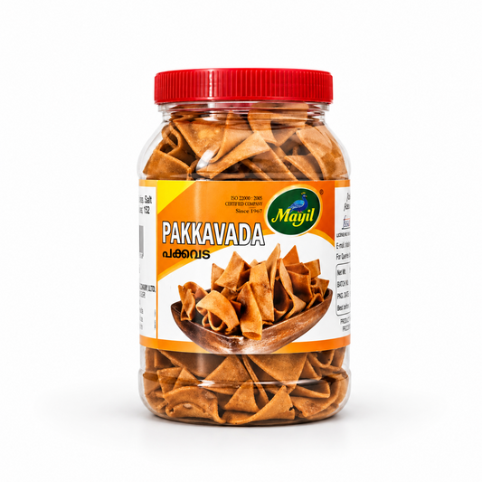 A transparent plastic jar of Mayil Pakkavada featuring a red screw cap and a yellow-and-white product label, centered on a solid white background. Available in the UK at theindianshelf.co.uk.