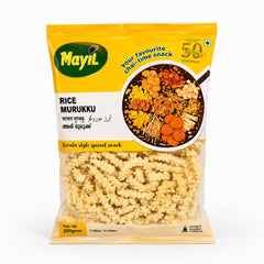 A professional studio shot of the Mayil Rice Murukku packaging. The bag features a bright yellow top section with the green "Mayil" logo on the left and a "50 Plus Years" seal on the right. A circular graphic in the center showcases a variety of traditional Kerala snacks. The bottom half of the bag is transparent, revealing the pale-yellow, coiled, and bumpy-textured rice murukku inside.This product is available in the UK at theindianshelf.co.uk.