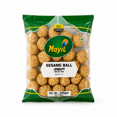 A professional studio product shot of a transparent plastic pillow pouch filled with golden-brown Mayil Sesame Balls against a solid white background. The pack is framed with a deep green border at the top and bottom. A large oval green logo in the center features the white brand name "Mayil" adorned with a peacock feather graphic. Below the logo, a white 