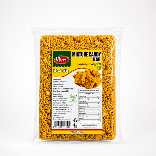 A professional studio shot of a transparent plastic wrapper containing a Meeval Mixture Candy Bar Through the clear film, the golden-yellow, highly textured, and compressed block of fried savory mixture strands is fully visible. The central rectangular label has a bright yellow background flanked by a dark green stripe on the left. The top left displays the red oval "Meeval Foods" logo with the tagline "Natural as it is".This product is available in the UK at theindianshelf.co.uk.