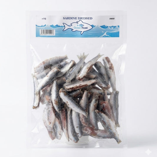 A clear, vacuum-sealed bag of OceanFeast Sardine Dressed. The pack contains several frozen, cleaned, and prepared sardines ready for cooking. The blue and white header label features the brand logo and the product name in English and regional Indian languages.