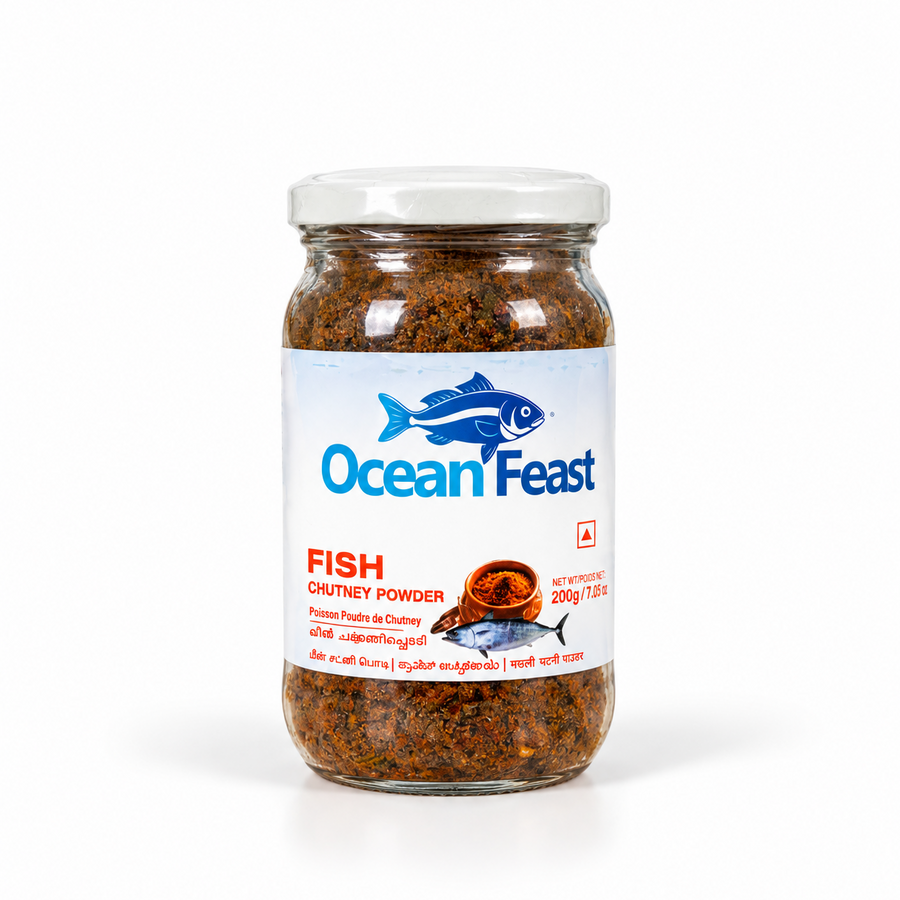 A 200g jar of Ocean Feast Fish Chutney Powder featuring a blue fish logo and multilingual labeling on a clear glass jar with a white lid. Available in the UK at theindianshelf.co.uk.