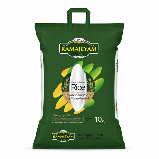 A professional studio product shot of a dark green rectangular rice sack with a built-in plastic carrying handle, standing vertically against a solid white background. The front of the bag features a gold-trimmed label at the top reading "RMJ RAMAJEYAM RICE". The center displays a large graphic of a single white rice grain superimposed over a dynamic fan arrangement of green and yellow paddy leaf shapes,This product is available in the UK at theindianshelf.co.uk.