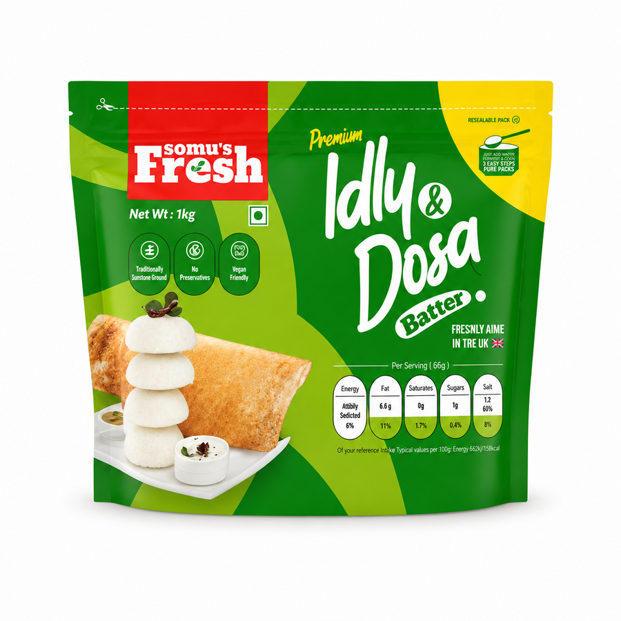 A studio product shot of a 1kg resealable stand-up pouch of Somu's Fresh Premium Idly & Dosa Batter isolated against a white background. The green and yellow packaging features a stack of idlis, a crisp dosa, and a nutritional chart.