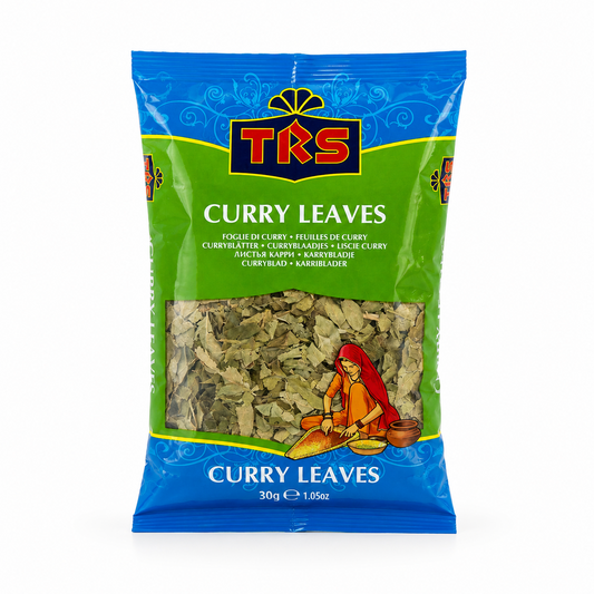 A 30g pouch of TRS Curry Leaves centered on a solid white background, featuring a vibrant green and blue packaging design with the TRS logo and a clear window showing dried green curry leaves next to an illustration of a traditional Indian woman. This product is available in the UK at theindianshelf.co.uk.