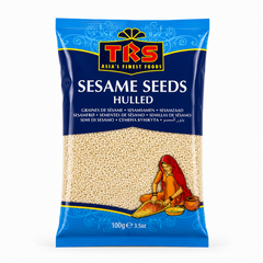 A 100g pouch of TRS Sesame Seeds Hulled centered on a white background, featuring a vibrant blue packaging design with the TRS logo and a clear window displaying cream-colored hulled sesame seeds next to an illustration of a traditional Indian woman. This product is available in the UK at theindianshelf.co.uk.