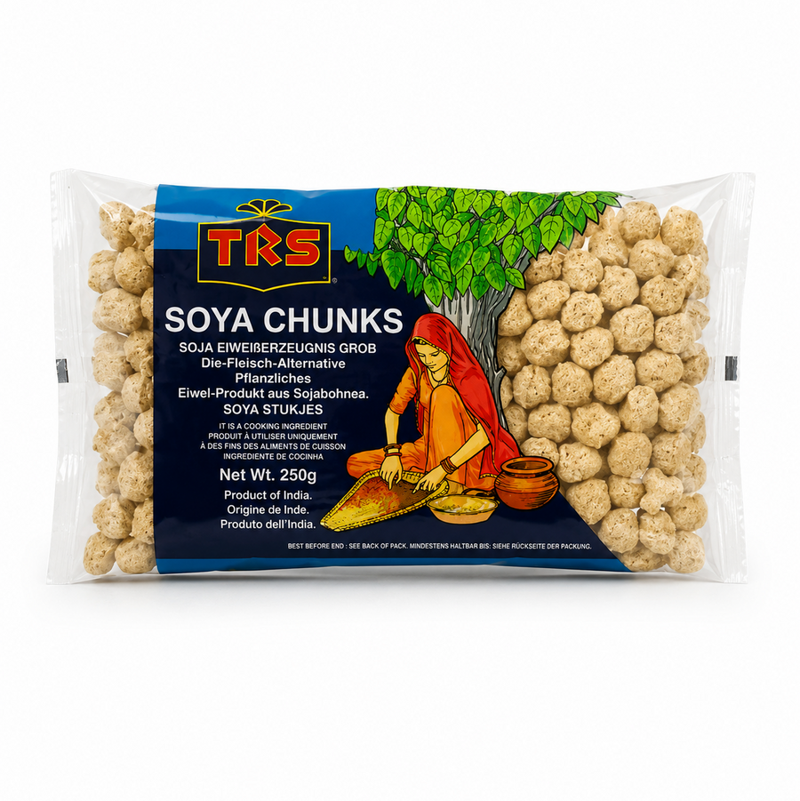 A 250g horizontal pouch of TRS Soya Chunks centered on a solid white background, featuring a dark blue and green packaging design with the TRS logo and a clear window displaying textured beige soya chunks next to an illustration of a traditional Indian woman under a tree. This product is available in the UK at theindianshelf.co.uk.
