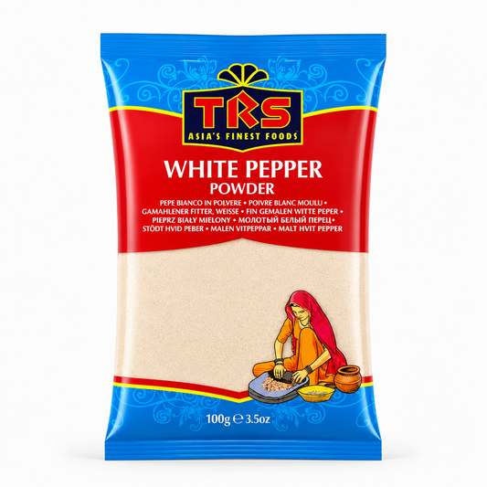 A 100g pouch of TRS White Pepper Powder centered on a solid white background, featuring a vibrant red and blue packaging design with the TRS logo and a clear window displaying off-white finely ground pepper next to an illustration of a traditional Indian woman using a grinding stone. This product is available in the UK at theindianshelf.co.uk.