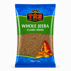 A 100g pouch of TRS Whole Jeera Cumin Seeds centered on a solid white background, featuring a vibrant green and blue packaging design with the TRS logo and a clear window showing whole cumin seeds next to an illustration of a traditional Indian woman. This product is available in the UK at theindianshelf.co.uk.