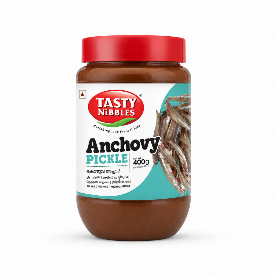 A professional studio product shot of a clear glass jar filled with a dark red Tasty Nibbles Anchovy Pickle, standing vertically against a solid white background . The jar is capped with a solid red screw-on lid. The white wrap-around label features a teal wave accent, showcasing the red oval "TASTY NIBBLES" logo above the prominent black title "Anchovy PICKLE".This product is available in the UK at theindianshelf.co.uk.