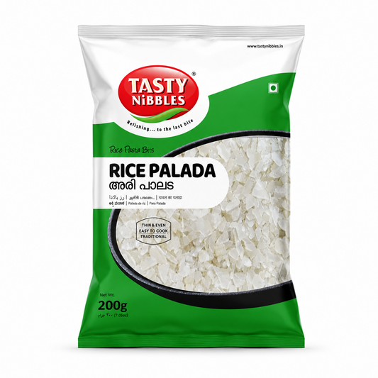 A studio product shot of a 200g vertical pouch of Tasty Nibbles Rice Palada against a plain white background. The package features a bright green and white theme,  logo positioned at the top left. A large circular cut-out window in the center reveals a bowl filled with white, thin rice palada flakes. A small badge on the window reads "THIN & EVEN | EASY TO COOK | TRADITIONAL". The bottom left corner indicates the net weight as "200g". This product is available in the UK at theindianshelf.co.uk.
