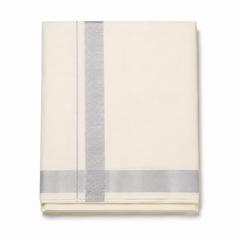 A neatly folded cream men's Kerala kasavu mundu (dhoti) centered on a solid white background, featuring a wide silver zari border running vertically, a parallel fine silver stripe, and a matching silver border along the bottom hem. Available in the UK at theindianshelf.co.uk.