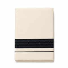 A neatly folded cream men's Kerala mundu (dhoti) centered on a solid white background, featuring a wide horizontal textured black woven border (kara) and a thin parallel black accent stripe near the bottom edge. Available in the UK at theindianshelf.co.uk.