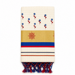 A neatly folded off-white tissue saree centered on a solid white background, featuring fine grid patterns, hand-painted blue and red floral motifs, a golden kasavu border with a red hand-painted floral emblem, royal blue and red accent stripes, and dual-tone blue and red knotted tassels at the bottom fringe.