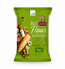 A bright green, 1 kge bag of India Gate Rice Flour. The packaging prominently features the India Gate logo and an appetizing arrangement of South Indian rice-based dishes, including idlis, vadas, dosa, and sambar, arranged around a long, rolled dosa on a banana leaf. The bag highlights its quality with seals for "NATURALLY GLUTEN FREE," "CONSISTENT QUALITY," and "PERFECT FLAVOR & AROMA."