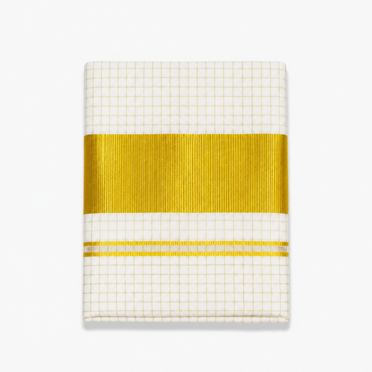 A close-up folded view of an off-white Kerala tissue cotton kasavu single set mundu centered on a solid white background, displaying an all-over golden check grid pattern and a wide horizontal metallic gold zari border with fine accent lines. Available in the UK at theindianshelf.co.uk.