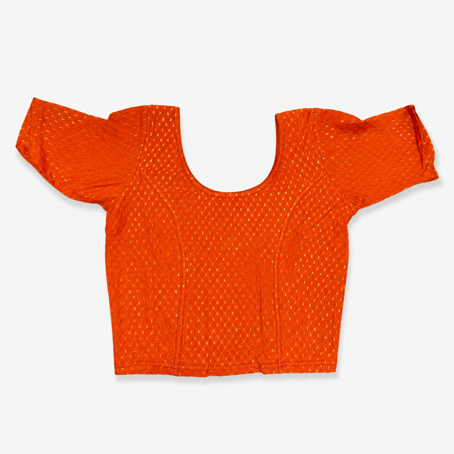 A vibrant orange short-sleeved stretchable readymade saree blouse with a textured jacquard micro-pattern and deep scoop neckline, laid flat against a solid white background. Available in the UK at theindianshelf.co.uk.