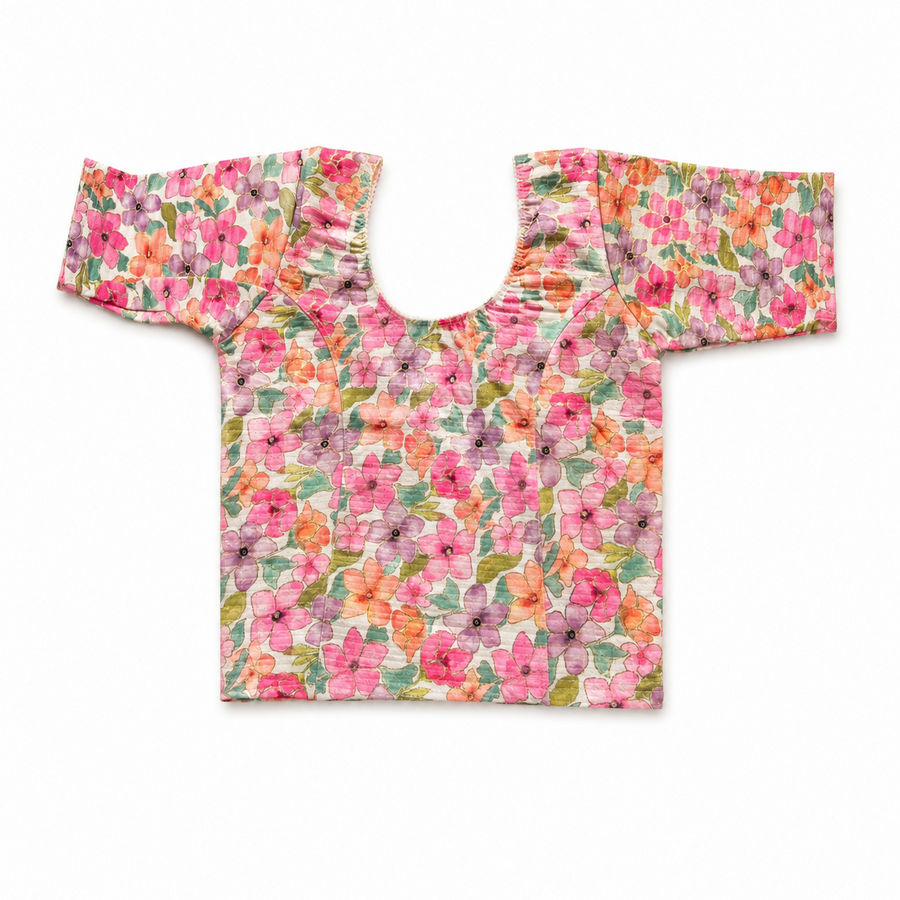 A colorful floral print readymade stretchable saree blouse displayed flat on a white background, featuring short sleeves, a scoop neck, and a vibrant pattern of pink, orange, and purple flowers. Available in the UK at theindianshelf.co.uk.