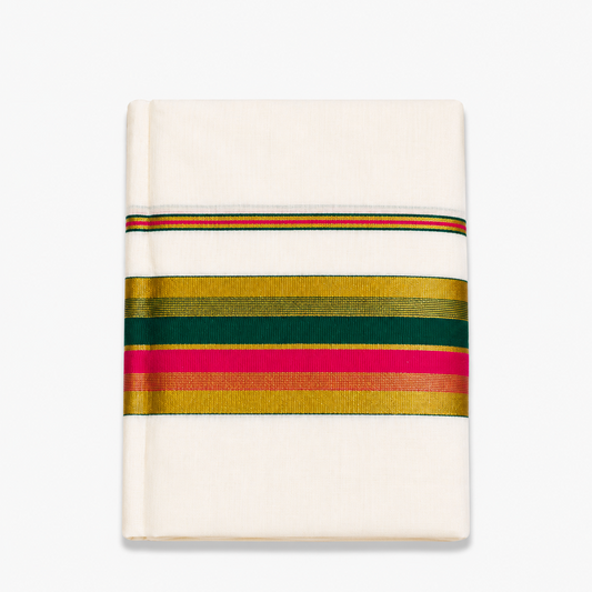 close-up folded view of an off-white Kerala cotton kasavu set mundu centered on a solid white background, displaying horizontal metallic gold zari bands interwoven with vibrant pink and deep green border stripes. Available in the UK at theindianshelf.co.uk.