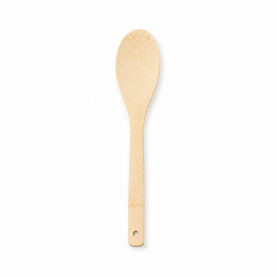 A natural light wood oval cooking and serving spoon with a hanging hole at the handle tip, displayed vertically against a solid white background. Available in the UK at indianshelf.co.uk.