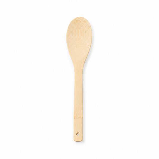 A natural light wood oval cooking and serving spoon with a hanging hole at the handle tip, displayed vertically against a solid white background. Available in the UK at indianshelf.co.uk.